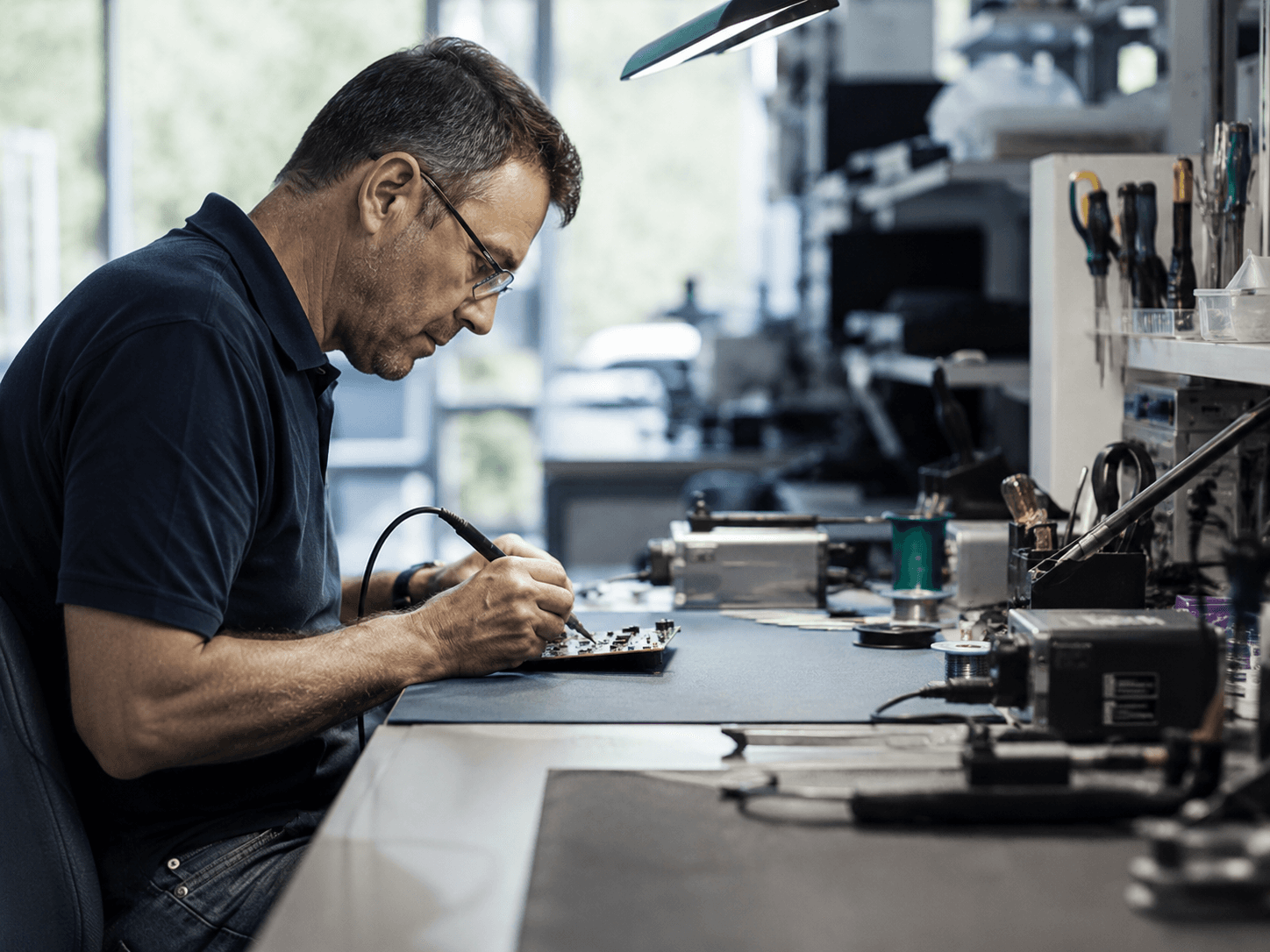 Techniker bei konzentrierter Feinarbeit im Elektroniklabor